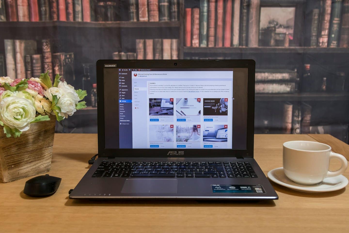 Laptop z interfejsem zaplecza strony internetowej obok jaskrów i filiżanki kawy.